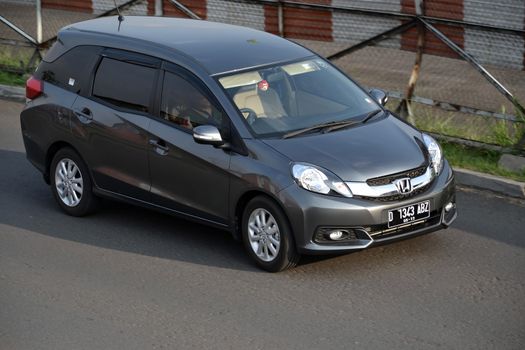 bandung, indonesia-june 16, 2014: grey colored honda mobilio cruising on the road.