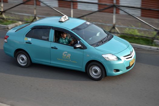 bandung, indonesia-june 16, 2014: gemah ripah taxi cruising on the road.