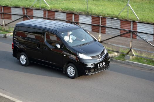 bandung, indonesia-june 16, 2014: black colored nissan evalia cruising on the road.