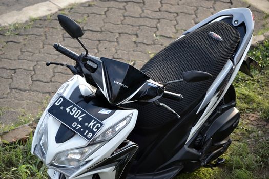 bandung, indonesia-june 16, 2014: honda vario cbs techno motorcycle parking at the side road.