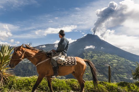 BANOS, ECUADOR - DECEMBER 10: Unrecognizable farmer on a horse looking at the  Tungurahua volcano eruption - december 10, 2010 in Banos, Cordillera Occidental of the Andes of central Ecuador, South America 