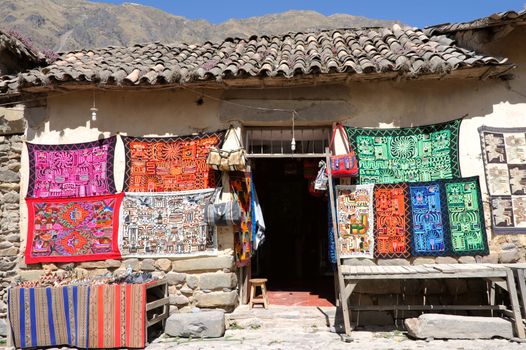 Traditional woven fabrics for sale at a tourist spot in the high Andes, Ollantaytambo, Urubamba Valley in Peru, on the road from Cuzco to Machu Picchu, Sacred Valley 
