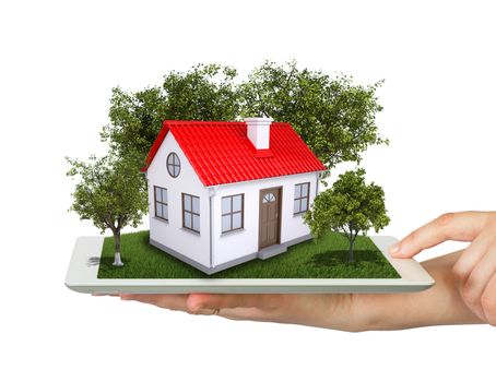 Hands holding a tablet pc and small house with land. Isolated on white background