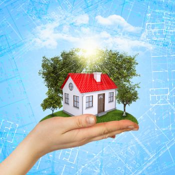 Hands holding a small house with land. Drawings on background