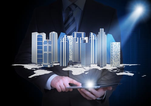 Man in suit holding tablet pc and city of skyscrapers in the hand. Spotlight shines skyscrapers