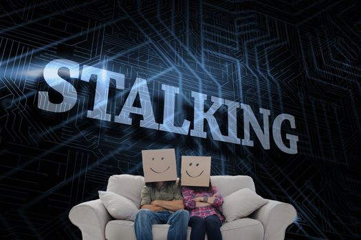 The word stalking and silly employees with arms folded wearing boxes on their heads against futuristic black and blue background