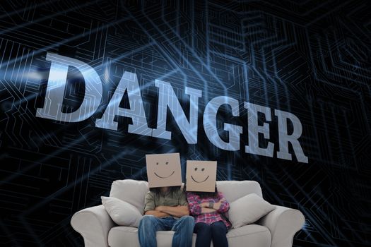 The word danger and silly employees with arms folded wearing boxes on their heads against futuristic black and blue background