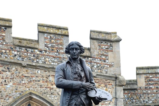 statue of gainsborough with church wall in background