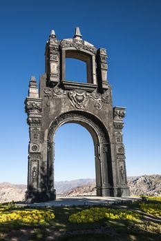  Ancient Ornate arch on top of Cerro Quilli, La Paz from above, with Nevado Illamani in the distance. Bolivia