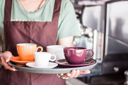 Coffee shop owner serving set of freshly brewed coffee, stock photo