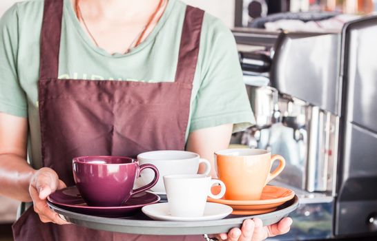 Barista preparing set of freshly brewed coffee for serving, stock photo