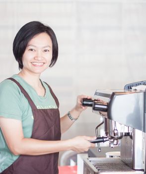 Woman barista at work in coffee shop, stock photo