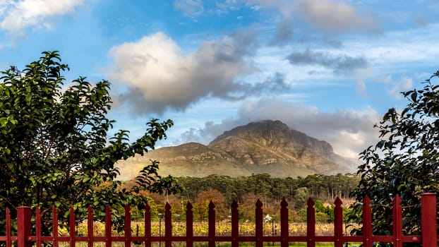 View of the beautiful rocky mountains of Stellenbosch behind a red fence