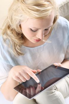 Figure of a young, beautiful blonde with a digital tablet, the woman touches the screen,