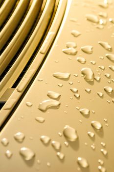 vehicle panel with raindrops on golden paintwork