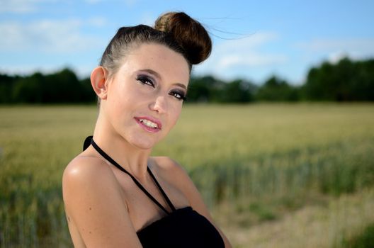 Outdoor portrait of young female model. Close portrait of Polish teenager with green fields and blue sky as background.