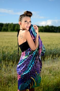 Female model from Poland, outdoor photo. Charming girl holds colorful skirt in her hand.