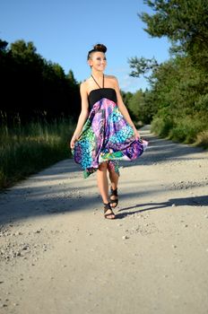 Outdoor photo of female model from Poland. Charming young girl is walking with colorful dress.