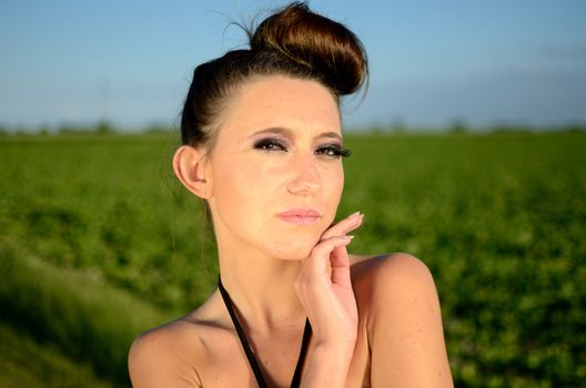 Outdoor portrait of young female model. Close portrait of Polish teenager with green fields and blue sky as background.