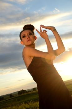 Polish female model outdoor photo. Young charming girl posing with sunset light as background.