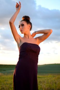 Beautiful girl from Poland, outdoor portrait. Young female model posing with different hands gesture. Blue sky with single clouds and green fields as background.