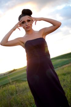 Beautiful girl from Poland, outdoor portrait. Young female model posing with different hands gesture. Blue sky with single clouds and green fields as background.