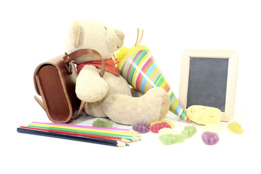 Teddy bear with school bag, wallet, sweets and board on a light background