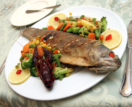 Fried trout with vegetables.