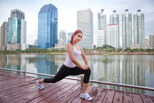 Beautiful young asian woman doing stretching exercise in the city