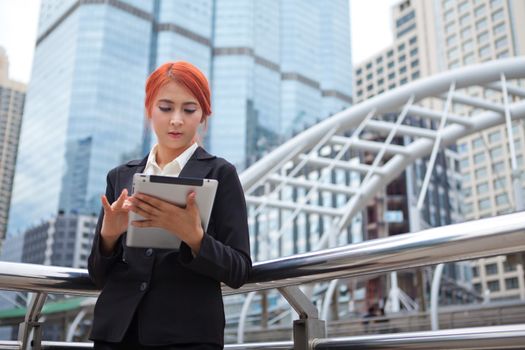 Young business asian woman with tablet at modern city