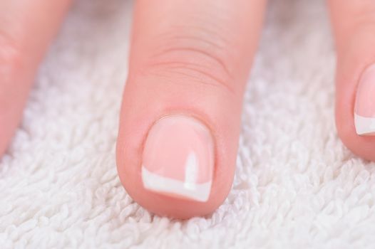 Fingers with french manicure on white towel