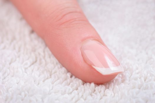 Fingers with french manicure on white towel