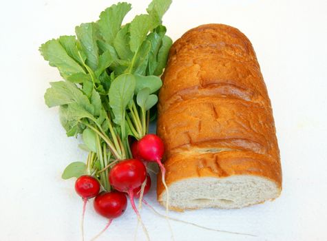 Long loaf of bread and radish on white background