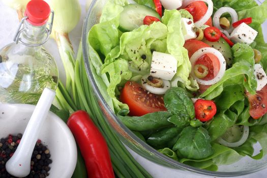 Salad with lettuce, tomato, cucumber, onion, olives clearing sauce.