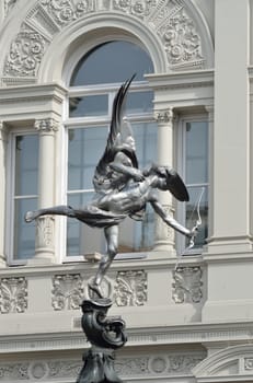 Eros statue with arch in background
