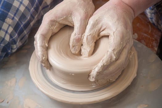 Hands of a potter, creating an earthen jar on the circle