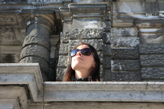 Young lady on the balcony of ancient building