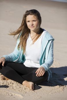 Teenage girl sitting in the beach