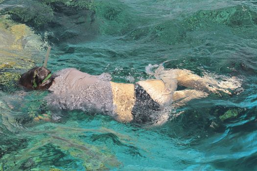 Woman photographer diving into water of Red sea