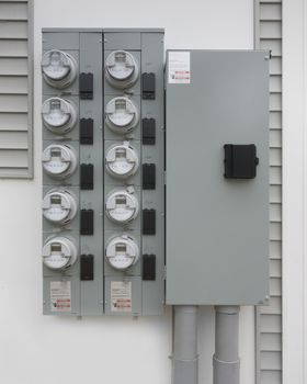 Individual smart digital electric utility meters on a panel for an apartment complex