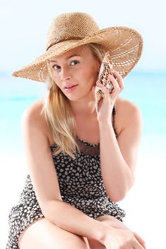 Woman in summer dress sitting on a deck chair and enjoy the sun bath