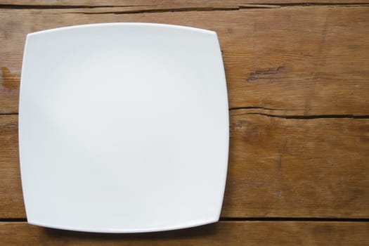 white ceramic square dish on the vintage wooden table
