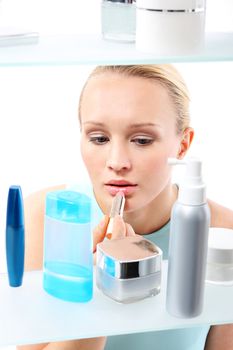 A woman stands at the client shelf and selects cosmetics