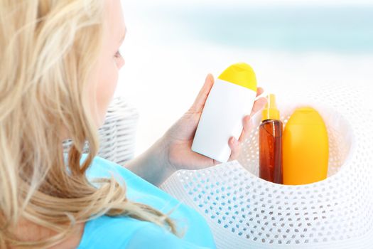 A woman sitting in a basket and reads the beach sun care