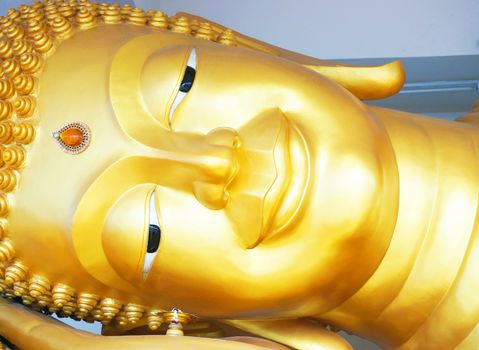 The face of Buddha an expression of kindness made of metallic gold.                               