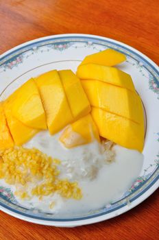 Thai style tropical dessert, glutinous rice eat with mangoes