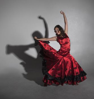 Young woman dancing flamenco, studio shot, gray background