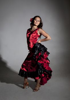 Young woman dancing flamenco, studio shot, gray background