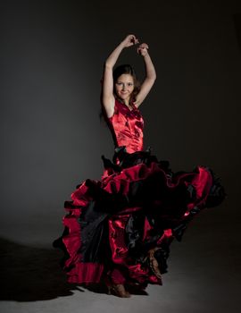 Young woman dancing flamenco, studio shot, gray background