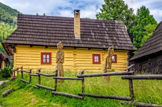 View of traditional village house and wooded statues, Vlkolinec, Slovakia